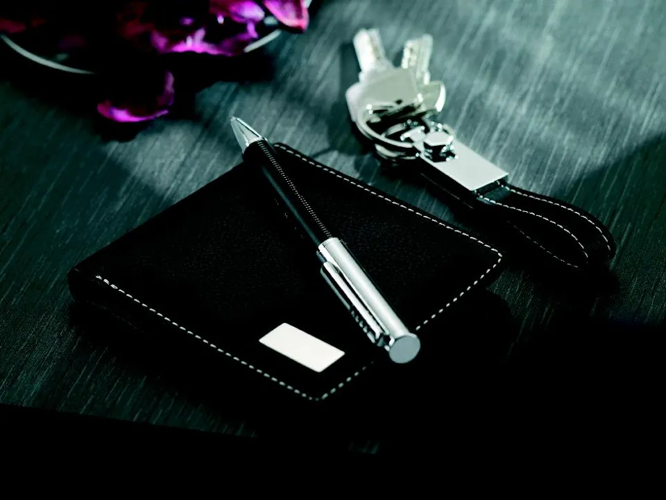 Coffret avec porte-cartes, stylo et porte-clés sur fond sombre